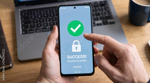 Close-up of hands holding a smartphone displaying a success access granted message and green checkmark for cybersecurity and digital identity protection.