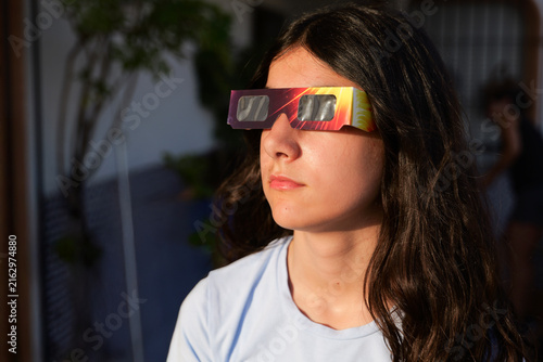 Girl looking solar eclipse with protective glasse