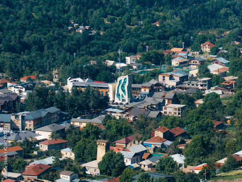 Aerial view of Mestia featuring modern architecture and traditional stone houses nestled within lush green forests in the Caucasus Mountains, Mestia, Samegrelo-Zemo Svanet, Georgia.