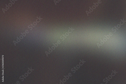 Dark, grainy textured background with a subtle, horizontal band of soft, diffused light and color.