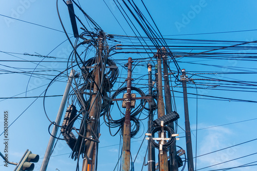 Quadro su tela Tangled wires stretch skyward against blue