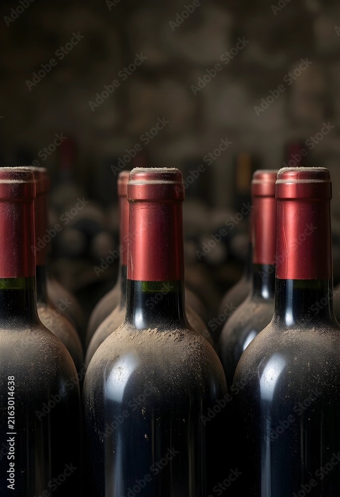 Naklejka premium Wine aging and vintage cellar concept, dusty red wine bottles stored in a dark underground winery