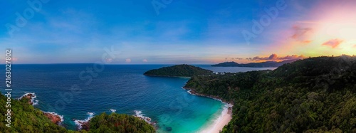 Panorama concept drone is relaxing on a pristine, tropical white sand beach, Freedom Beach, Phuket, Thailand, on a sunny day. It's a hidden tropical beach, deserted during the low season.