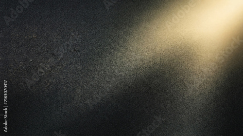 Dark Sand Grit Textured Plaster Wall Background With Warm Spotlight Beam