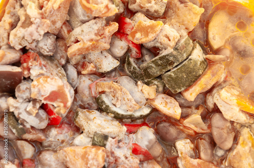 Close-up of spoiled and moldy vegetable stew with beans and zucchini covered in white mold fungus, abstract food waste background
