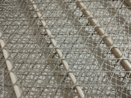 Принти на полотні Close-up view of a white mosquito repellent coil protected by a metal wire mesh, creating an intricate geometric pattern