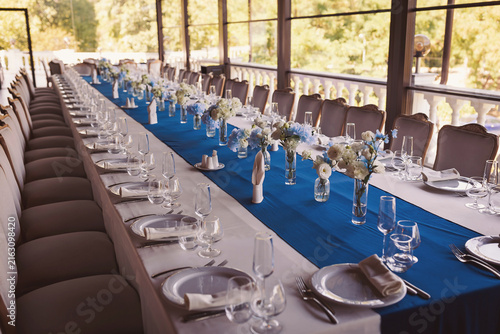 Wedding table settings. banquet table is decorated with plates, cutlery, glasses, candles and flower arrangements. 