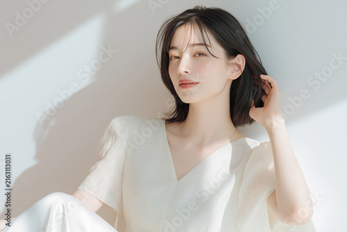 透明感のある白い肌の女性。ニュートラルトーンの背景。