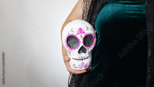 Canvastavla Portrait of a hand holding a decorative sugar skull in a studio, celebrating Day of the Dead with calavera motif, vibrant colors, remembrance, and ample copy space for text