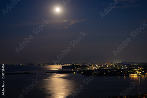 Fotografie Scenic view of the full moon over Lake Garda, Italy with moonlight reflection on
