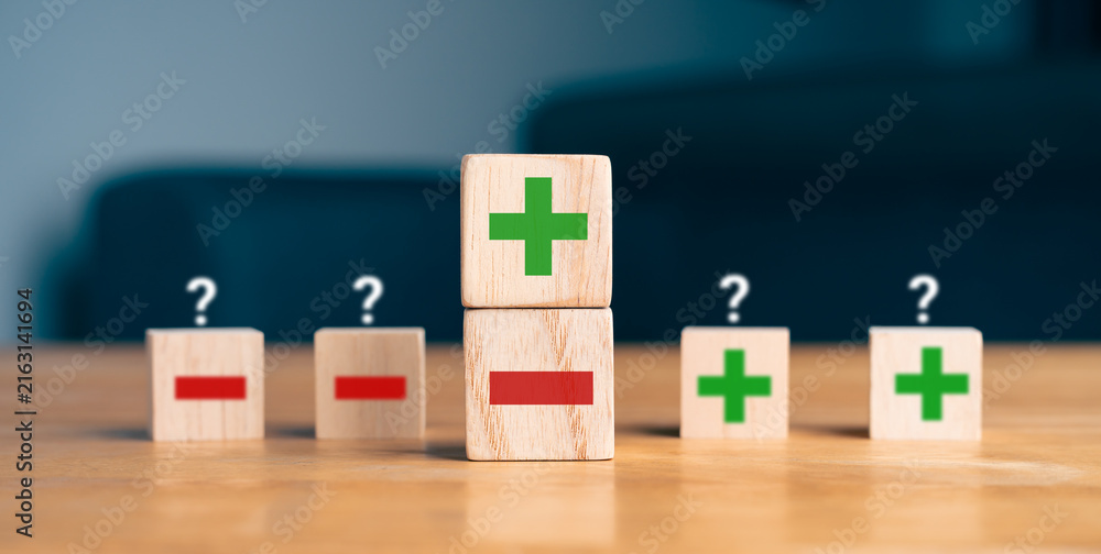 Obraz premium Pros and cons decision making concept with green plus and red minus symbols on wooden blocks
