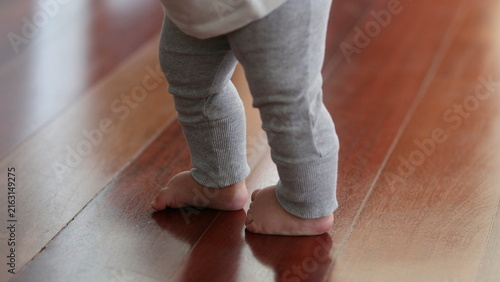 Fotografie Parent supporting baby toddler to walk