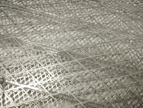 White spiral mosquito coil placed inside a metal holder, featuring a close-up view of the coiled structure and protective wire mesh. Suitable for concepts related to pest control, mosquito prevention,