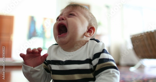 Fotografie Upset angry baby crying uncontrollably. Infant toddler tantrum