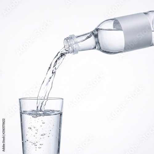 Clear water being poured from a glass bottle into a drinking glass on a plain white background, illustrating hydration and refreshment.