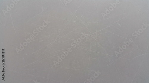 Gray textured surface featuring many fine white scratches across the smooth matte plastic material finish