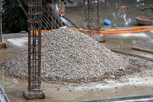 Fotografía Crushed stone gravel pile lying on concrete floor beside reinforced steel pillar frame
