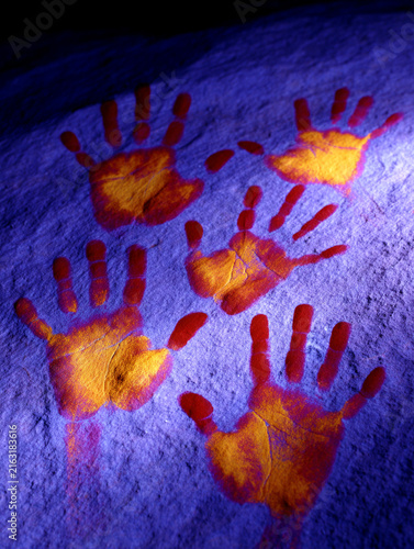 Yellow Handprints Painted on a Purple Textured Stone Rock Surface