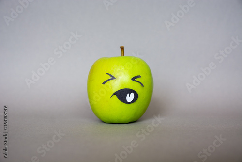 Photography Funny green apple  Face  character with confused  expression on grey background