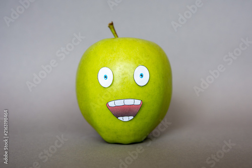 Quadro su tela Funny green apple  Face  character with confused  expression on grey background