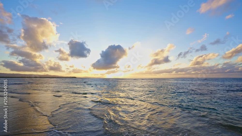 A gentle summer sunset over a calm sea, a beautiful natural backdrop. The golden sun rises over the Caribbean Sea, bathing the calm waters in a warm glow. Twilight over the sea.
