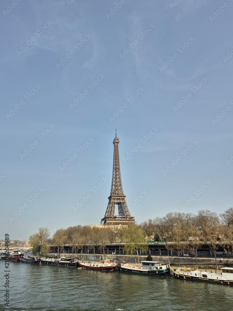 Fototapeta premium A wide daytime view of the Eiffel Tower in Paris, France, standing tall under a clear blue sky