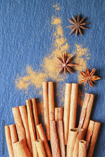 Cinnamon sticks and star anise on black table. Flat lay, copy space