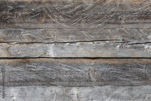 Obraz na plátně Close up full frame view of rough weathered horizontal wooden planks displaying natural grain, knots, and deep cracks, providing a textured gray background with ample copy space