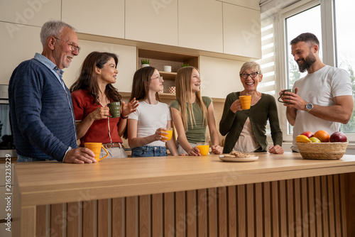 Family generations gathering in kitchen for coffee, juice and conversation