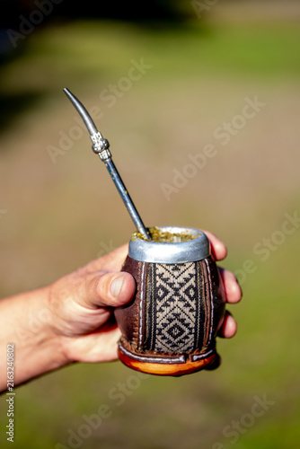 Obraz na plátne Man holding calabash Latin American yerba mate in nature