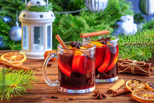 Christmas mulled red wine glühwine with aromatic spices and citrus fruits on a wooden rustic table, close-up. Traditional hot drink at Christmas or New Year time