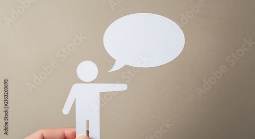 Paper cutout person with a blank speech bubble pointing to the side on a beige background.