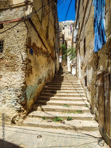Cuadro en lienzo Narrow stone staircase winds between crumbling weathered apartment buildings in