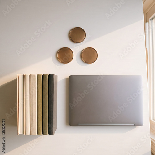 Top view of blank medallion badges with laptop and books on white desk