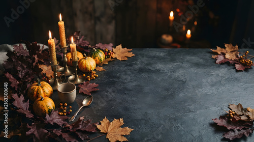 Candles and autumn leaves on dark water for memorial or fall celebration background