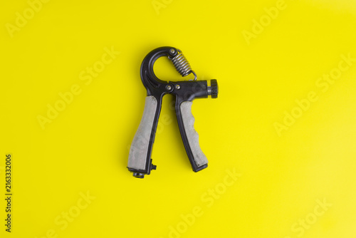 Foto Flat lay view of adjustable hand gripper on bright yellow background