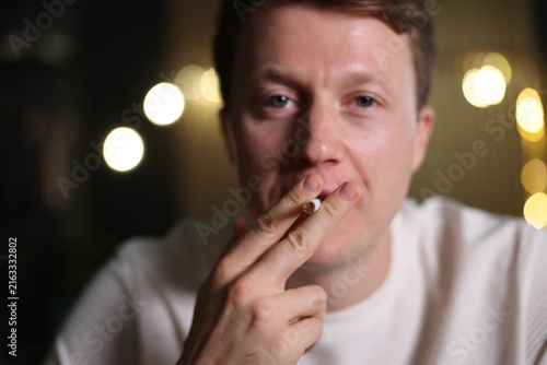 фотографія Man smoking cigarette on blurred background. Bad habit