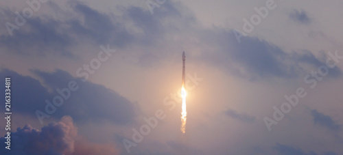 Photography Rocket launching into cloudy sky at dusk with dramatic light