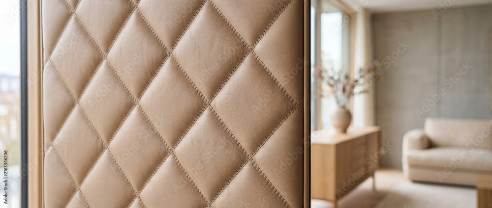 Naklejka premium Close-up quilted leather room divider panel in modern beige living room with sofa and vase