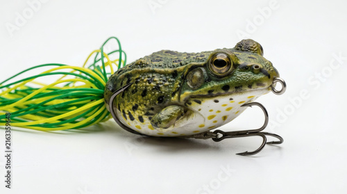 A realistic frog lure with a hook, designed for fishing. The lure has green and yellow accents and is highly detailed, mimicking a real amphibian