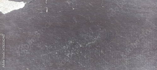 Dark weathered concrete texture with subtle scratches and worn marks, useful for industrial backgrounds, architectural designs, grunge compositions, and material overlays