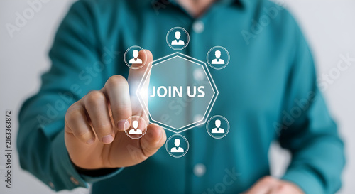 Businessman pressing a Join Us button on a digital holographic screen for recruitment and corporate team networking growth strategy