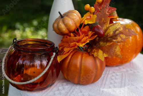 Halloween still life decoration with orange pumpkin and jack o lantern branch on table outdoor, autumn holiday party setup in garden