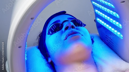 Woman receiving led light phototherapy facial treatment