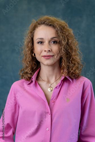 Cuadro en lienzo Stylish woman in pink button up shirt poses against textured backdrop