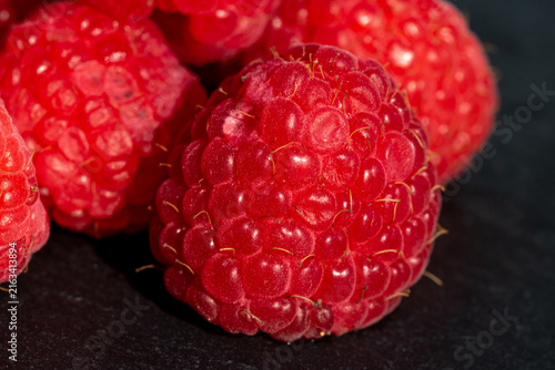 Fresh appetizing ripe raspberries in a detailed macro shot showing texture and vibrant red color