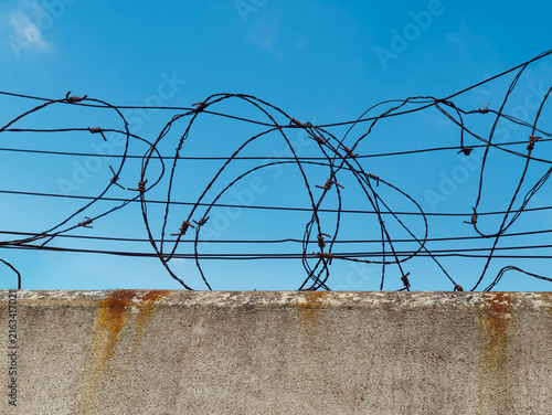 Fotografie Concrete wall with barbed wire, the concept of prison, salvation, Refugee, lonel