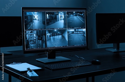 Multiple security camera feeds displayed on a dark monitor, monitoring interiors
