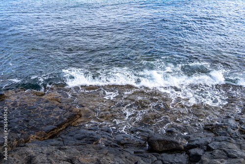 The Atlantic ocean waves crashing on the volcanic rocky coastline of Lanzarote, Canary Islands, creating a mesmerizing view.