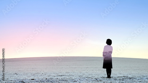 Photography Double exposure of a woman seen from behind on a snowfield blended with a pink d
